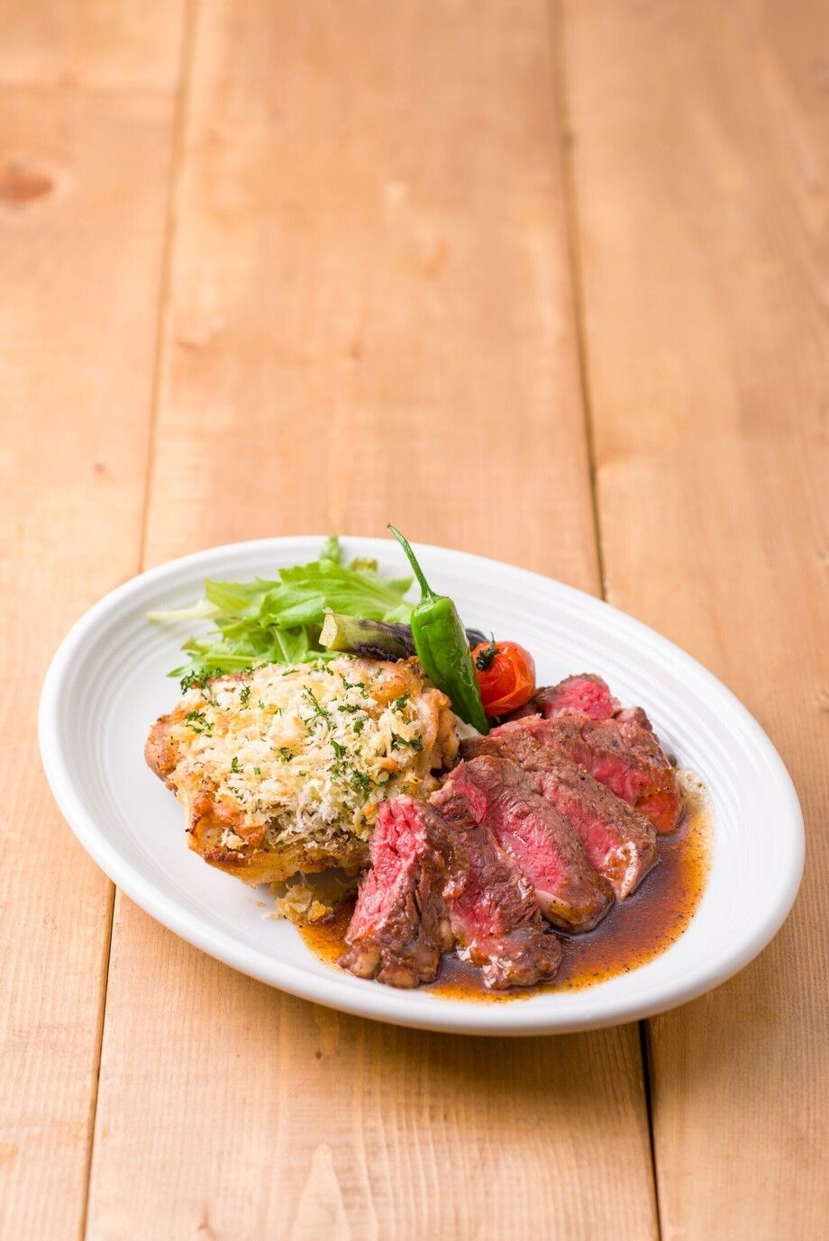 アンガス牛のステーキとチキンの香草パン粉チーズ焼き. ハーフ＆ハーフ盛り合わせ
